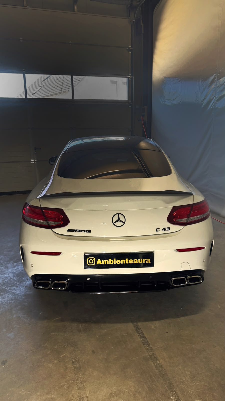 Weißer Mercedes-AMG C 43 Coupé von hinten